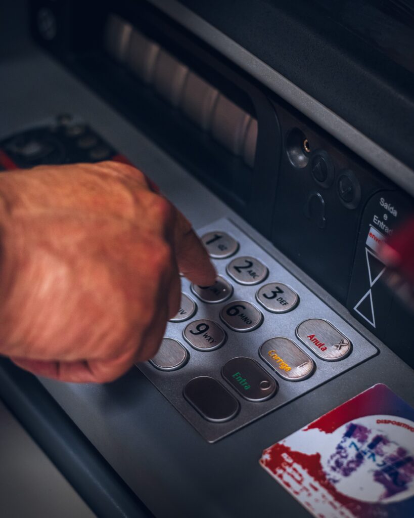 Person typing numbers into an ATM machine