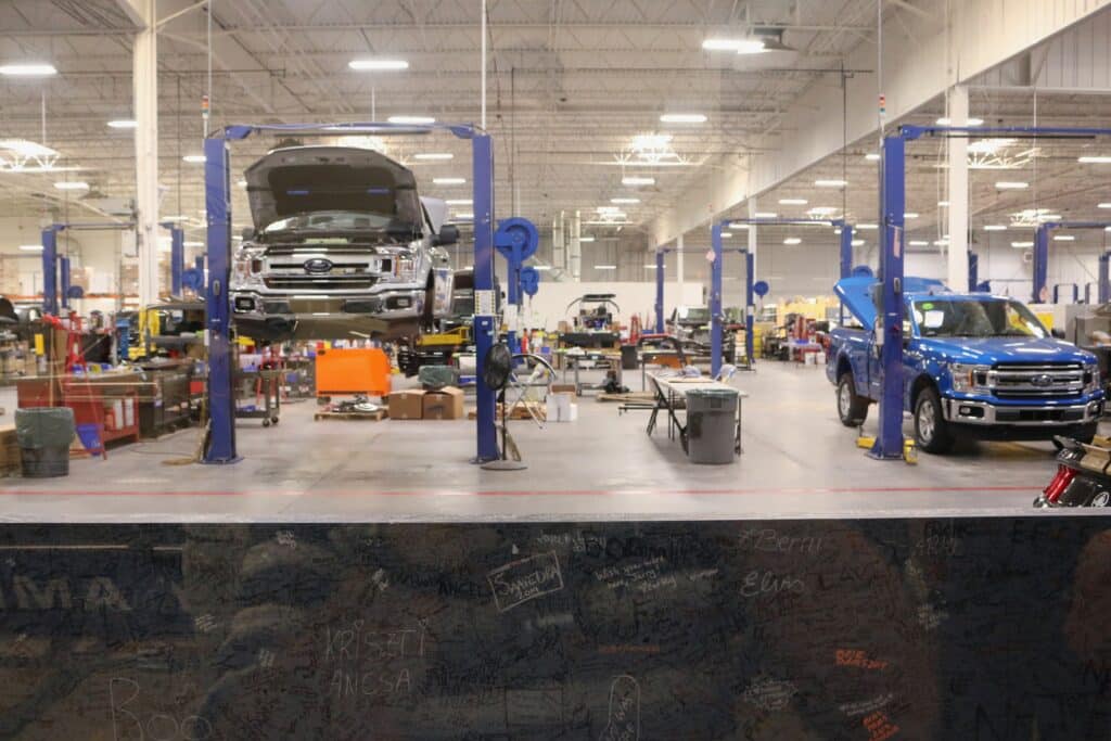 2 trucks being worked on in an autobody garage