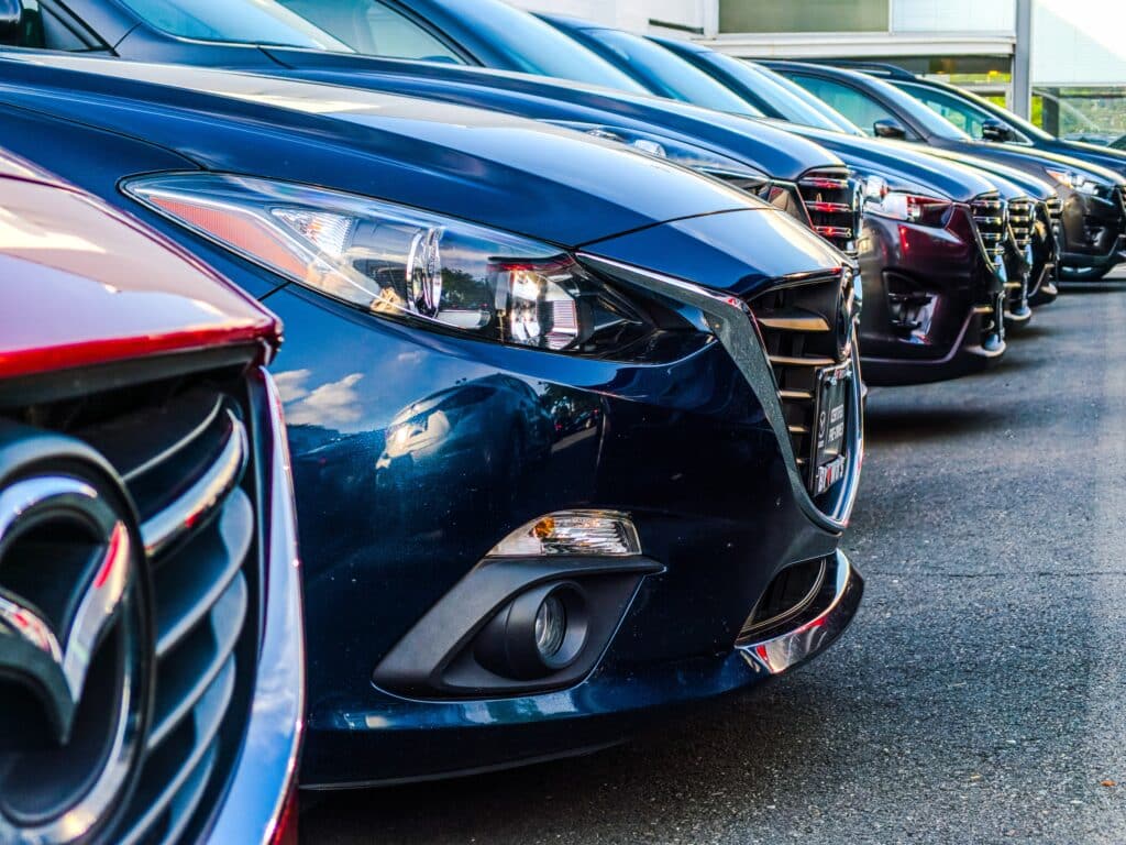 Front of a bunch of cars lined up in a dealership lot