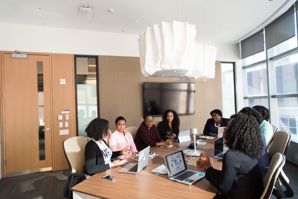 Group of people mid-discussion sitting at a conference table in a meeting room