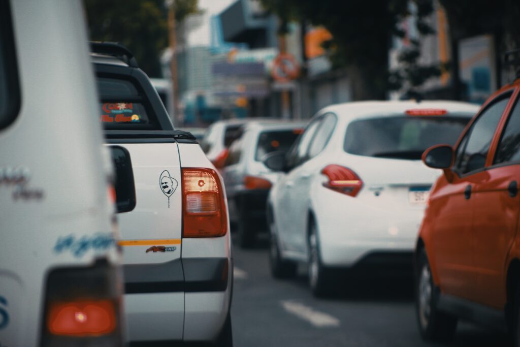 Handful of cars sitting in traffic on a busy road