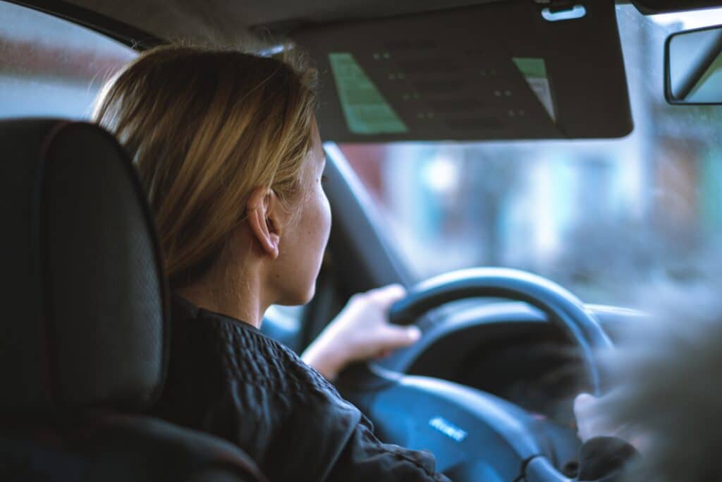 Close up of the back side profile of a woman driving a car