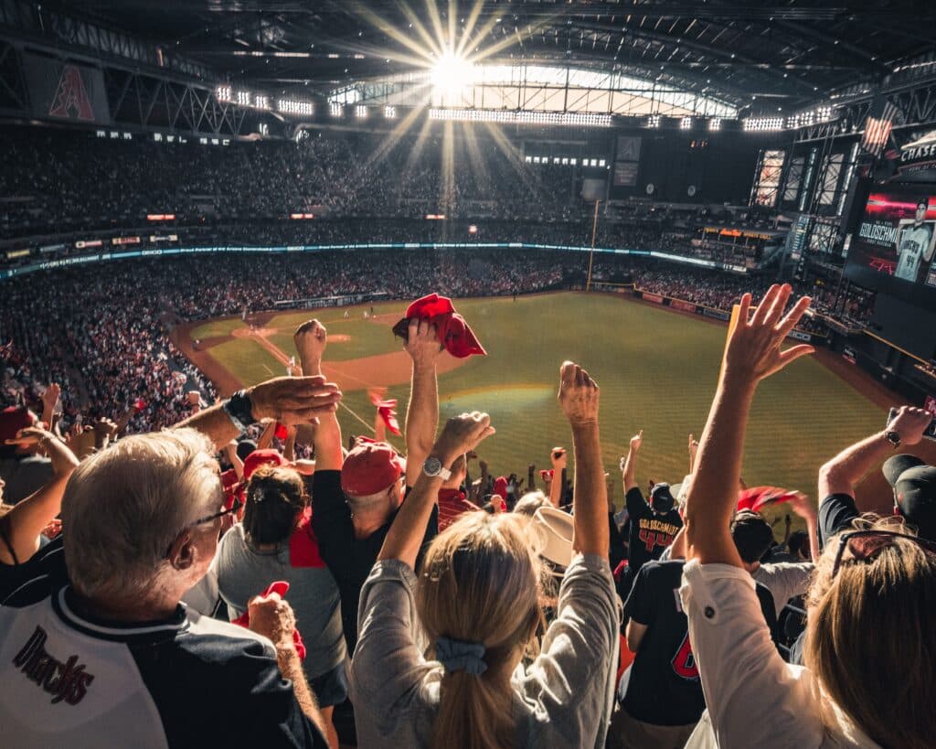 Fans with hands raised at an Arizona Diamondbacks game