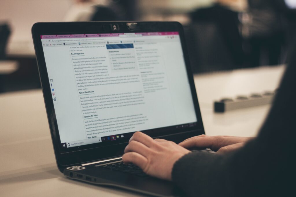 Person typing an article on a laptop