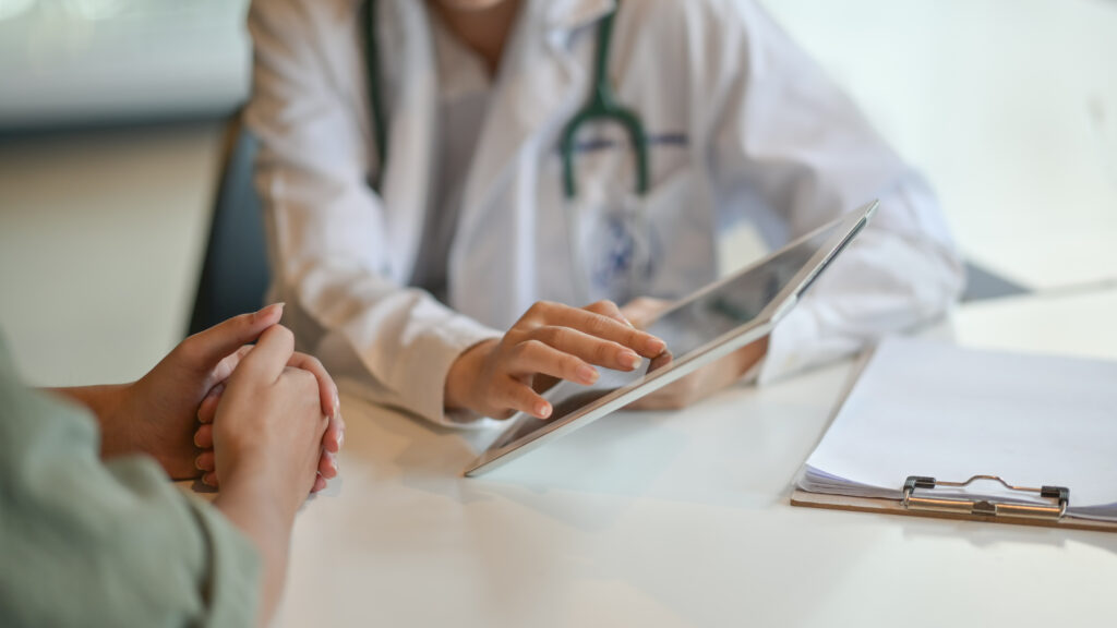 Shot of a doctor showing a patient some information on a digital tablet