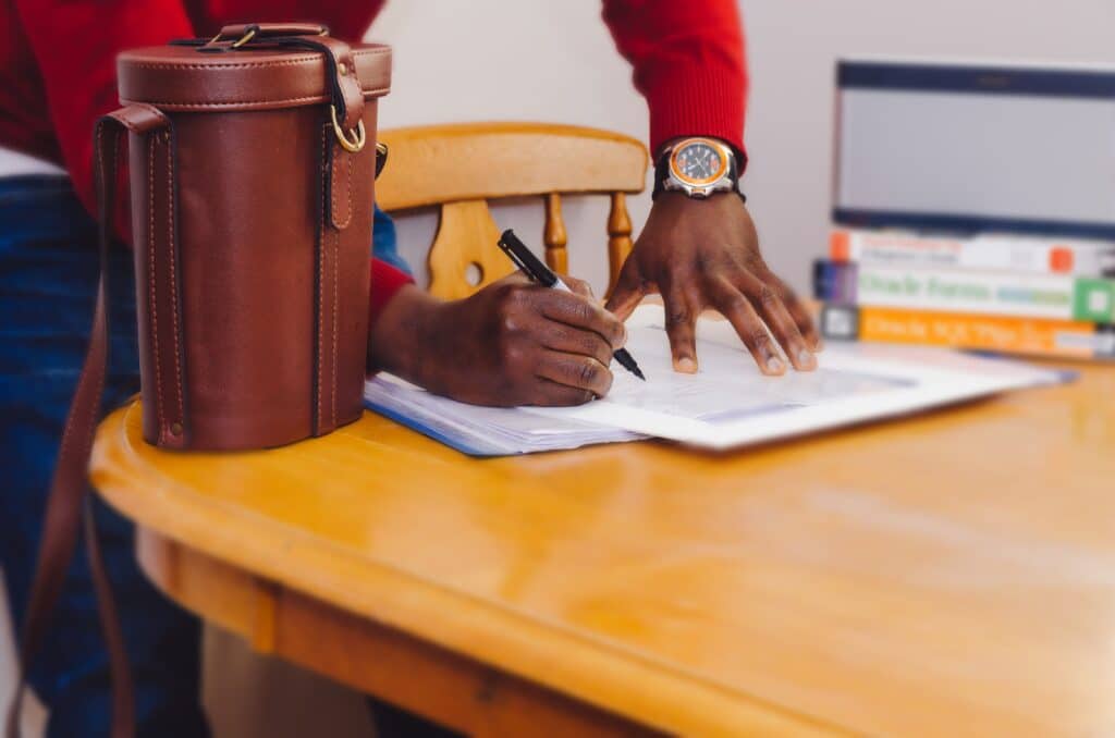 Hands of a person filling out loan application on paper