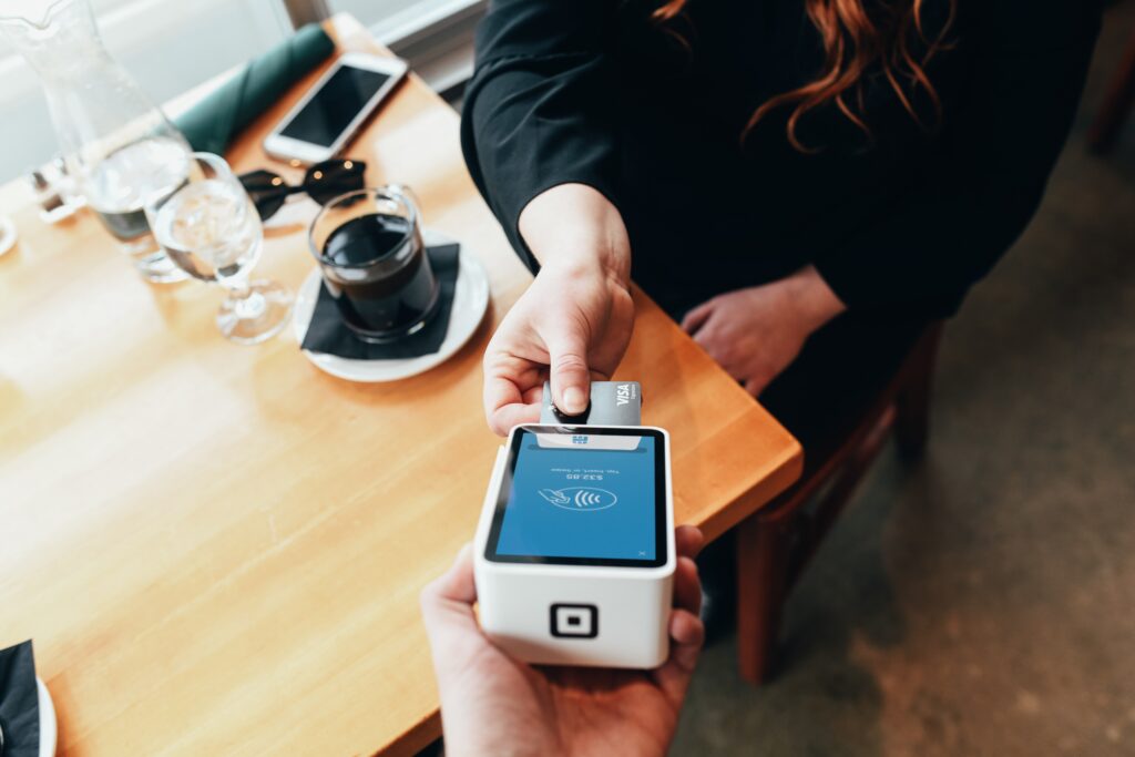 Person putting their card into a card terminal at a cafe