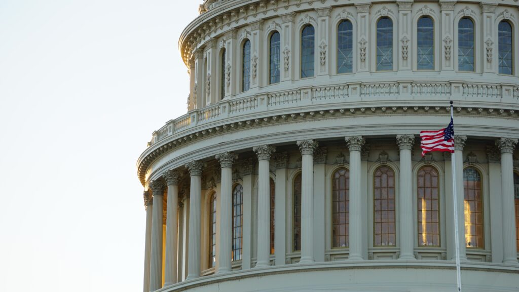 Zoomed in picture of part of the Capitol Building with an American flag flying