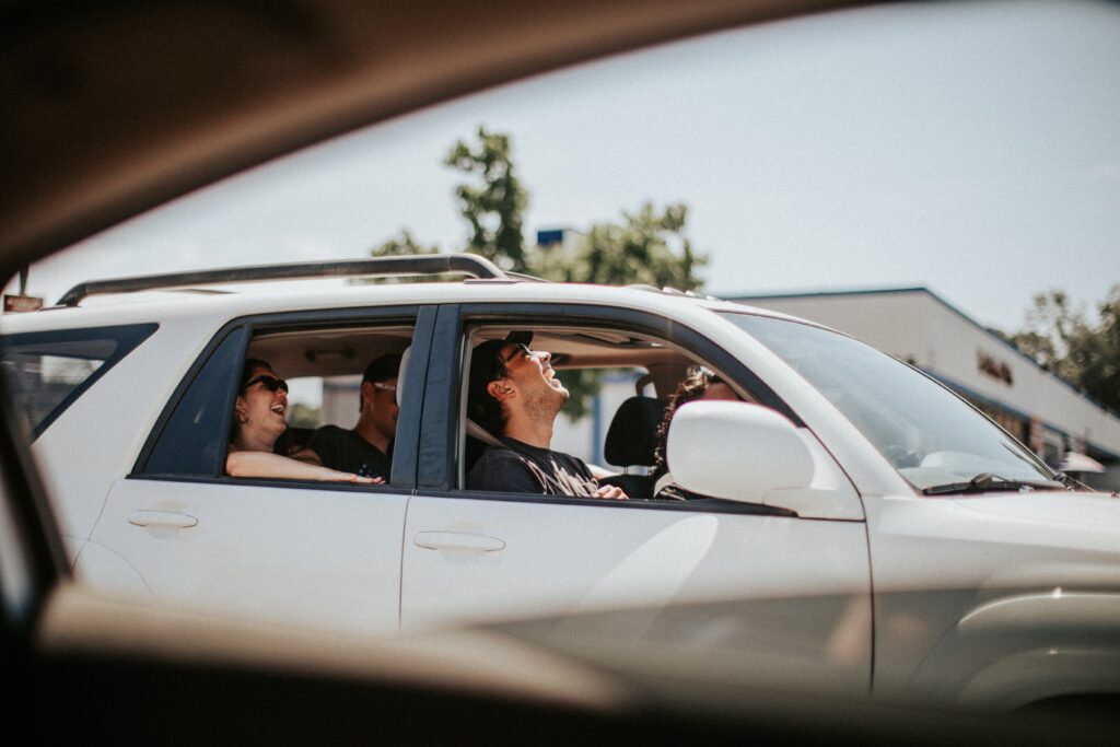 Group of people laughing while sitting in an SUV