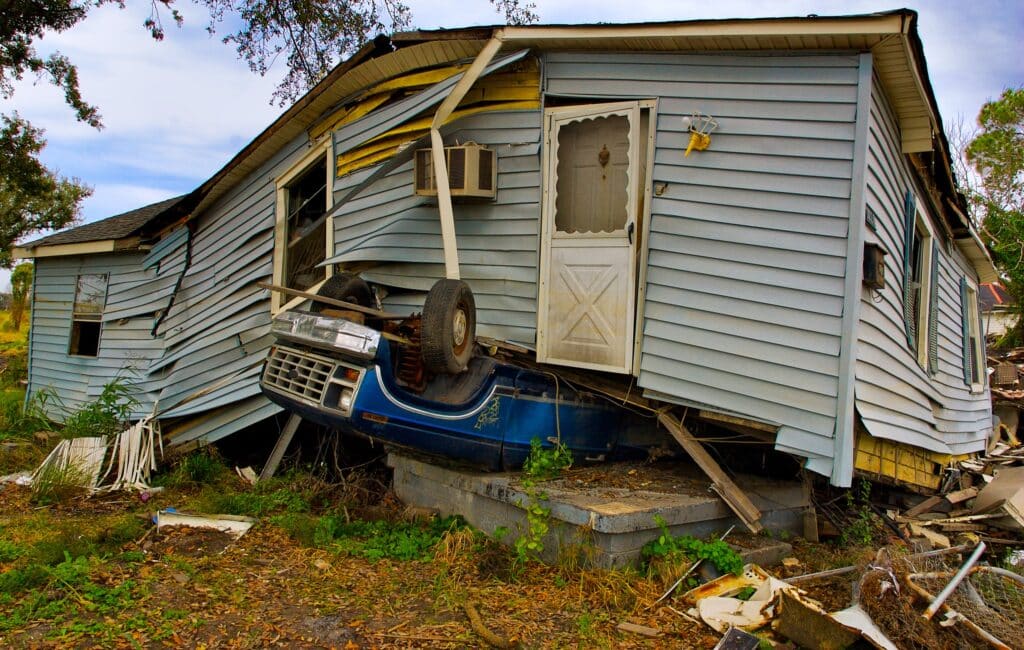 A house lifted off the ground by an upside down car underneath