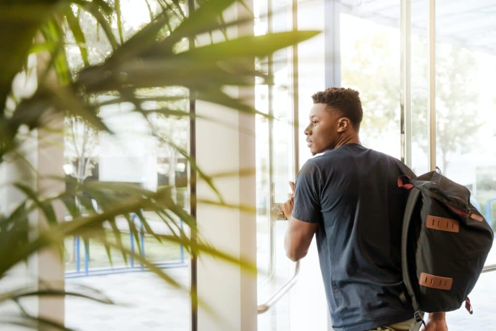 College student leaving building with backpack