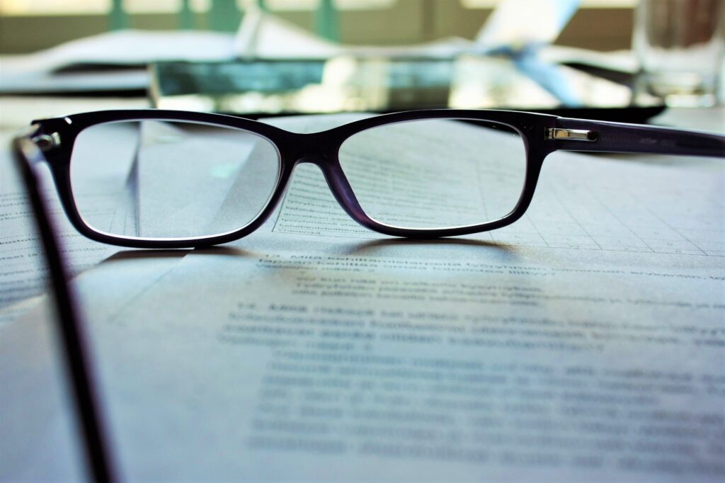 Eyeglasses on top of a stack of paper