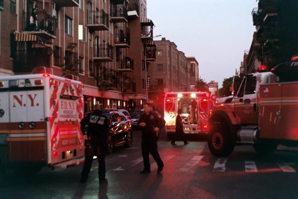 Paramedics standing in the street surrounded by ambulances after an accident