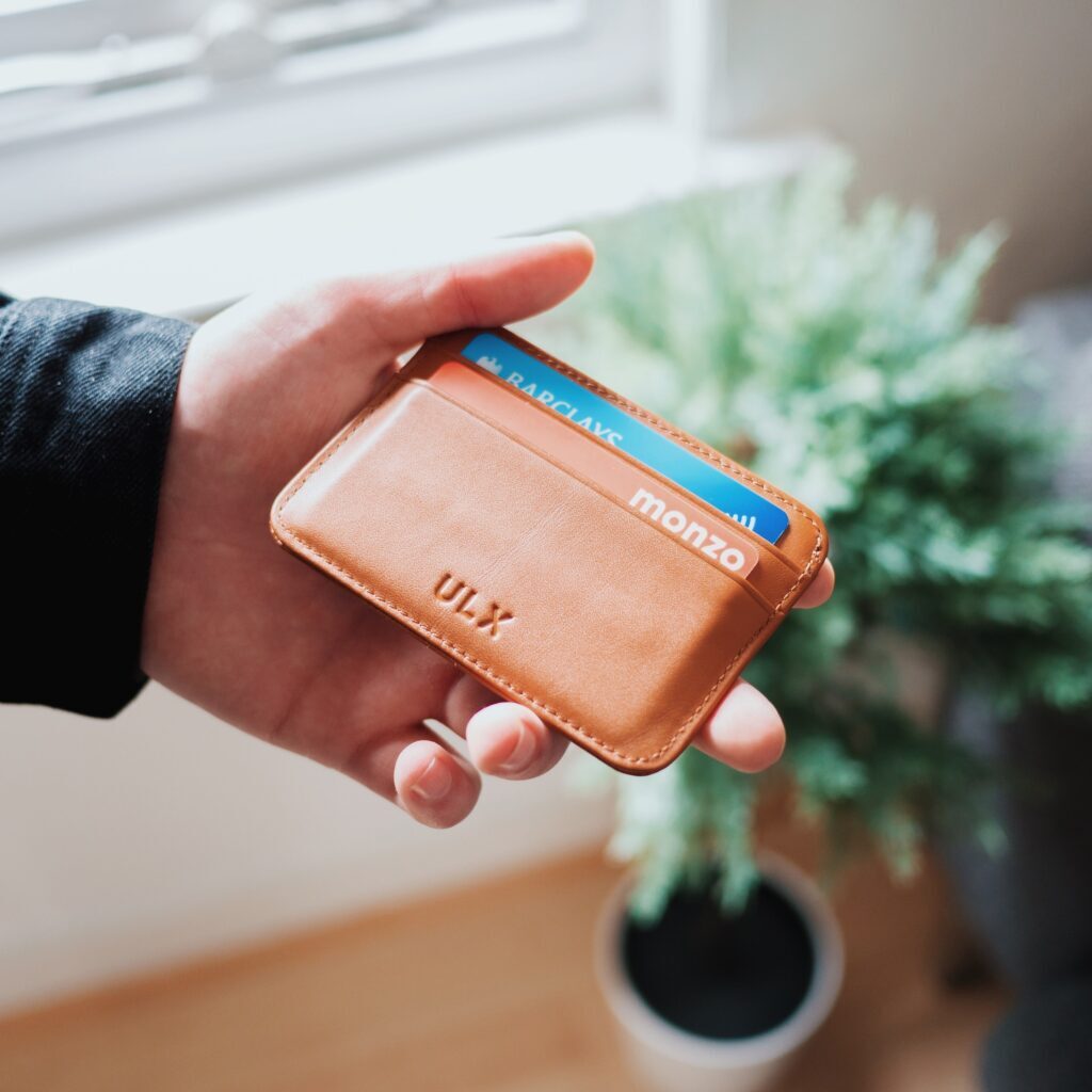 Hand holding a wallet with two cards showing