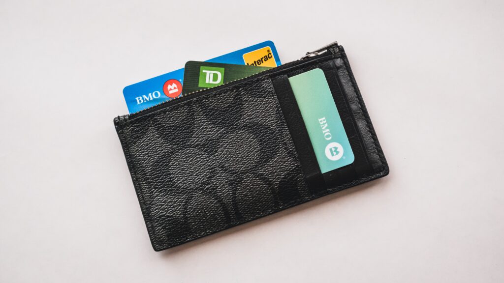 Black wallet with bank cards sticking out on a white background