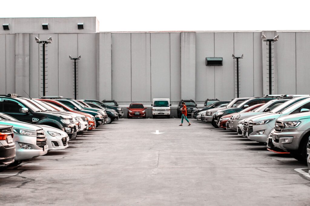 Woman walking in a lot full of cars