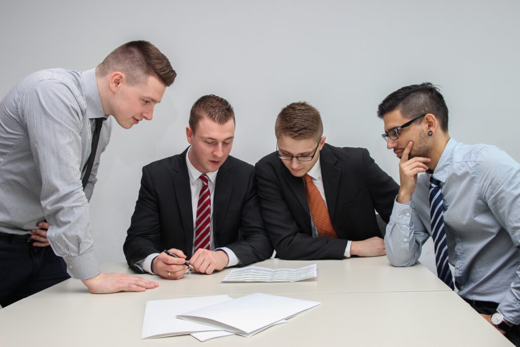 4 professionals looking over a document in a meeting