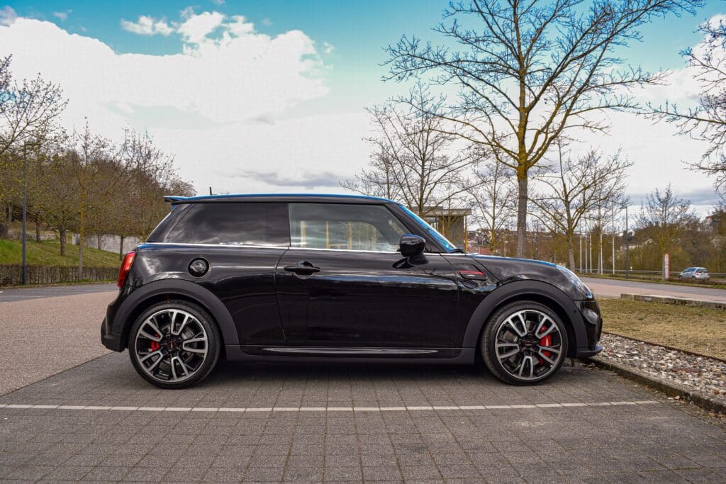 Side profile of a black two door car in a parking lot