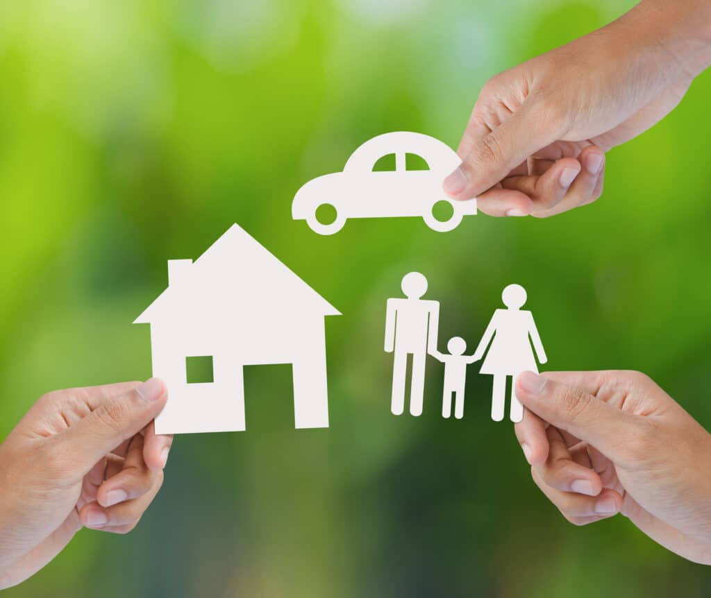 Hands hold icons of a house, car, and family