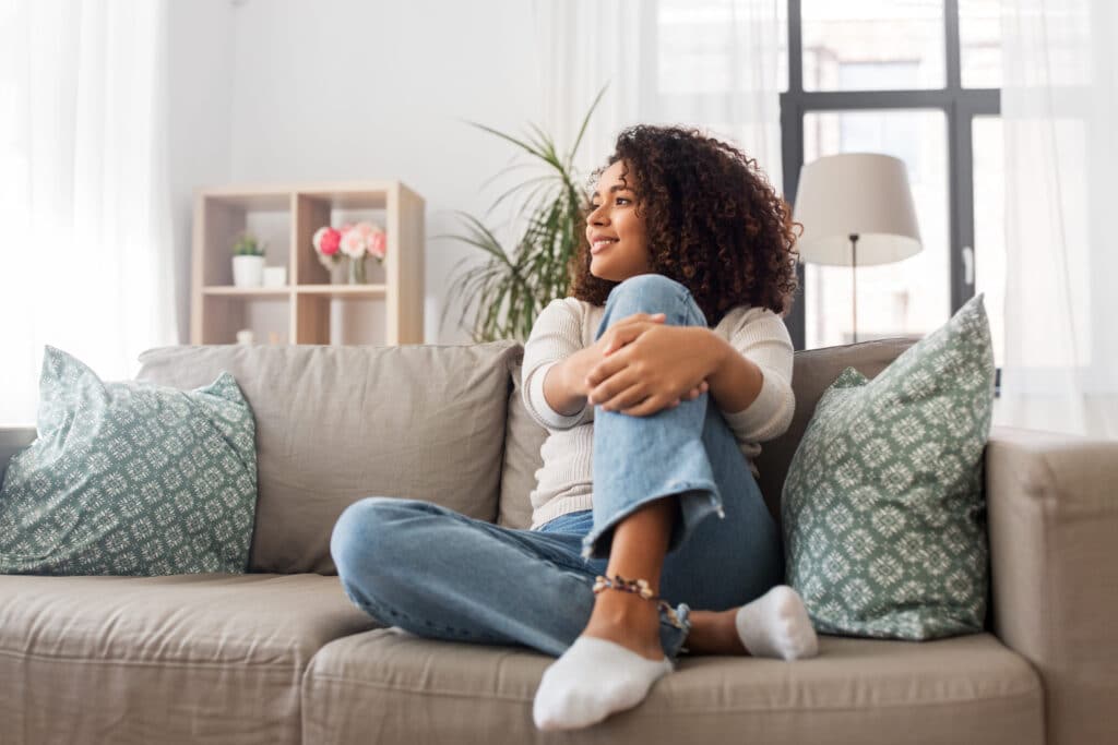 A woman sitting on her couch at home.