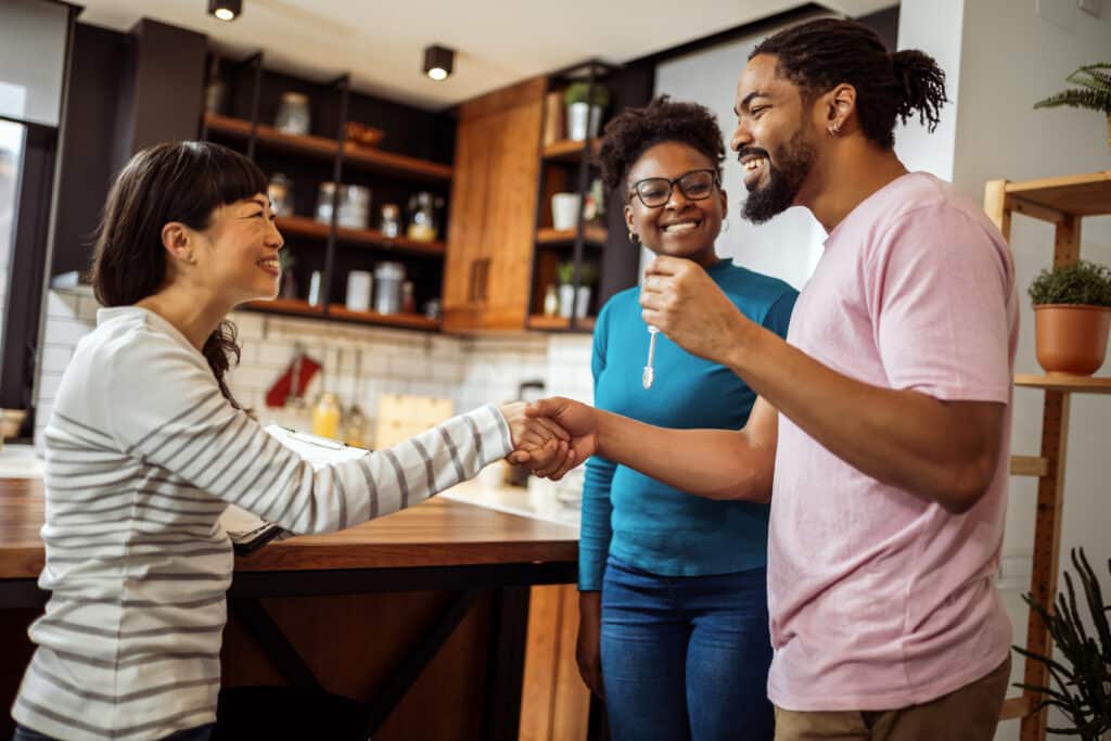 Couple getting keys from their real estate agent, for their new home.