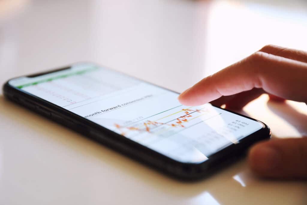 A person using a stock trading app on a smartphone, analyzing market trends. The best stock trading apps of 2025 offer commission-free trading and advanced tools for investors.